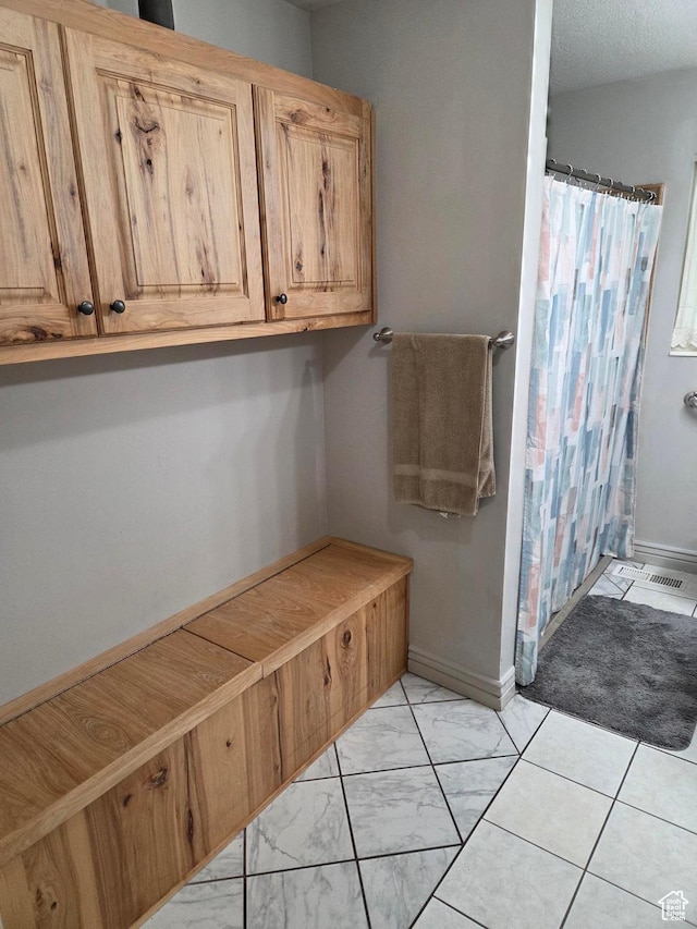 bathroom with a shower with shower curtain and baseboards