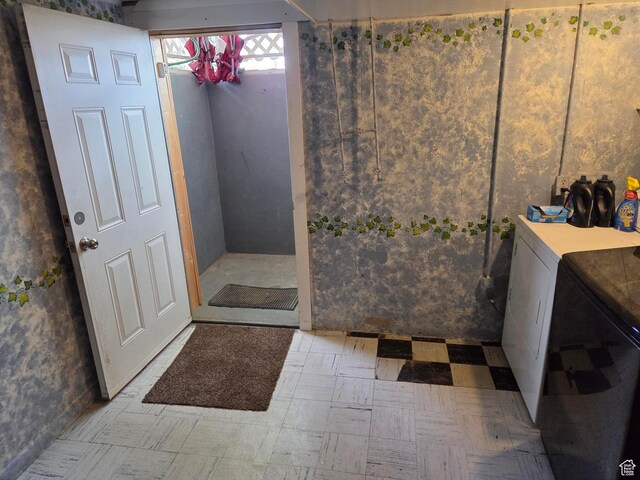bathroom with washer and clothes dryer and tile patterned floors