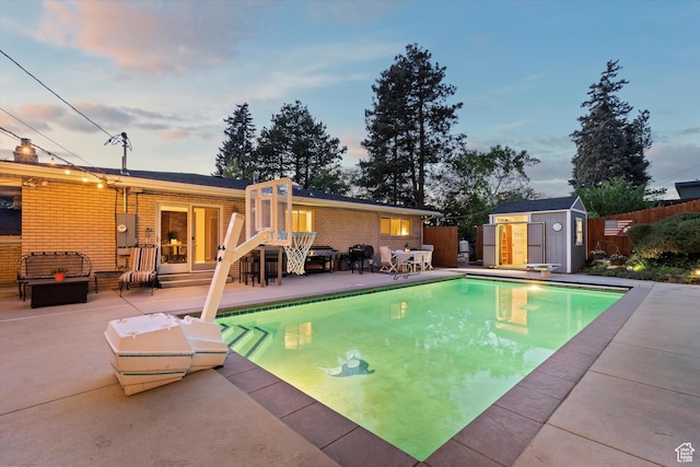 view of swimming pool featuring a patio area, a storage shed, fence, an outdoor structure, and outdoor lounge area