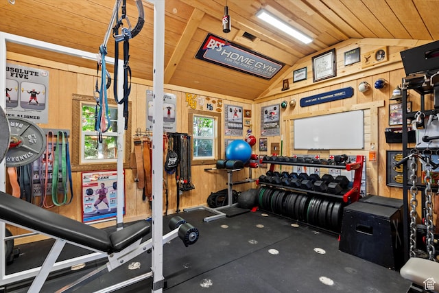 workout room featuring vaulted ceiling, wooden walls, and wood ceiling