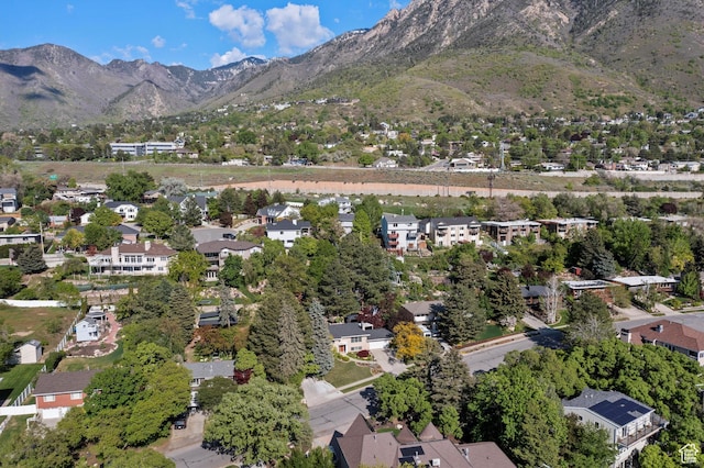 aerial view of property's location featuring a mountainous background and nearby suburban area
