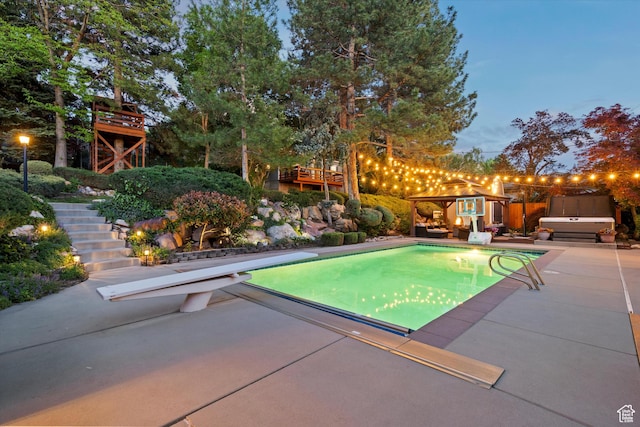 view of swimming pool featuring stairway, a diving board, and a patio area
