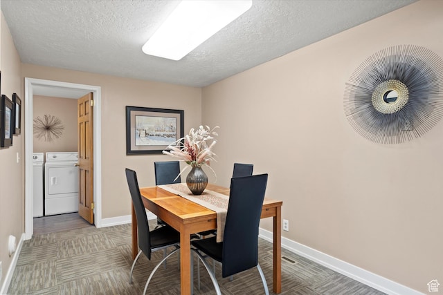 dining space featuring washer and clothes dryer, baseboards, and a textured ceiling