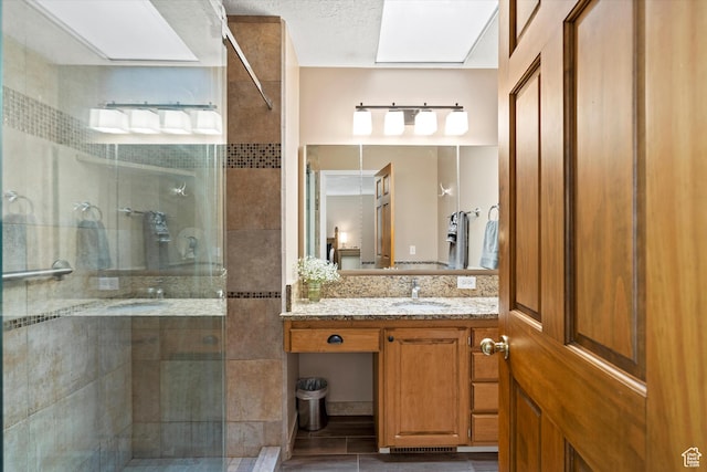 bathroom featuring a shower stall and vanity
