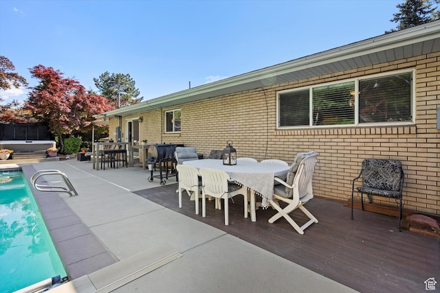 view of patio featuring outdoor dining space, a hot tub, and area for grilling