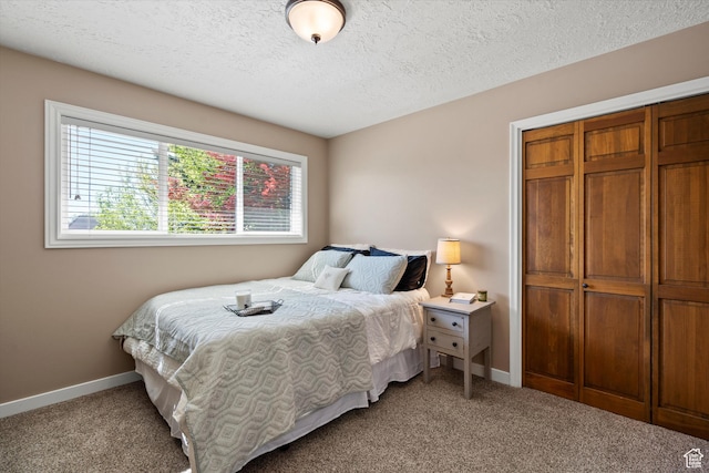 carpeted bedroom with baseboards, a closet, and a textured ceiling