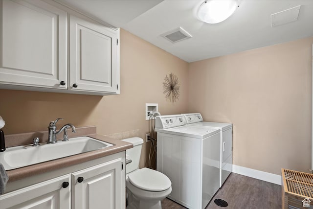 laundry area with washer and dryer and dark wood-style flooring