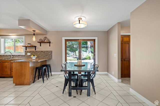 dining room featuring baseboards and light tile patterned floors