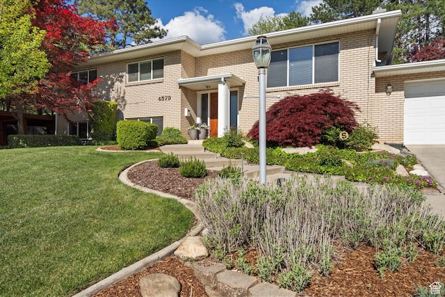 view of front facade featuring brick siding, a front lawn, and an attached garage