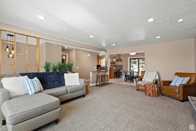 carpeted living room with a textured ceiling, recessed lighting, and baseboards