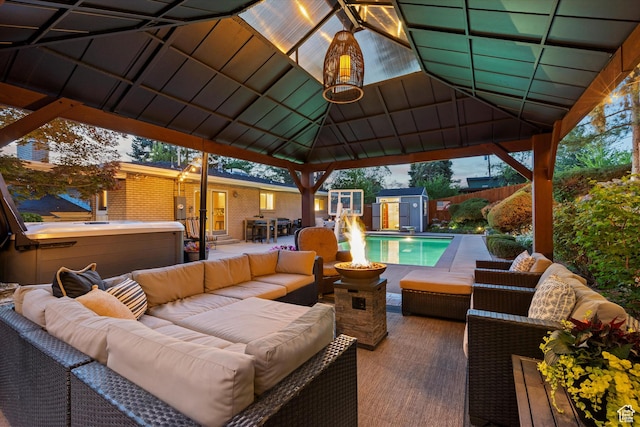 view of patio / terrace featuring an outdoor hangout area, a gazebo, fence, and a storage unit