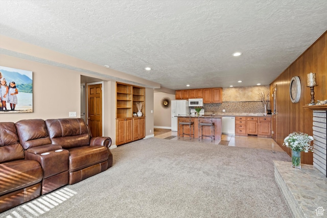 living area featuring a textured ceiling, recessed lighting, light carpet, and baseboards