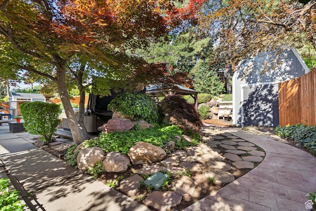 view of yard with a patio, fence, and an outdoor structure