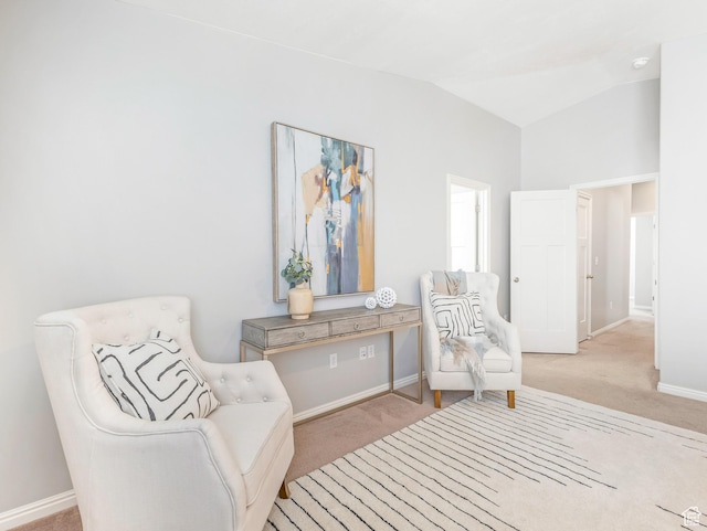 living area with carpet flooring, lofted ceiling, and baseboards