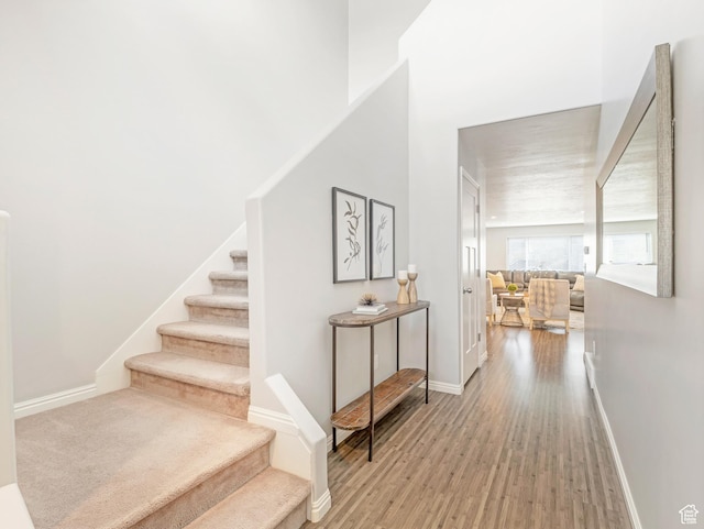 stairway featuring wood finished floors and baseboards