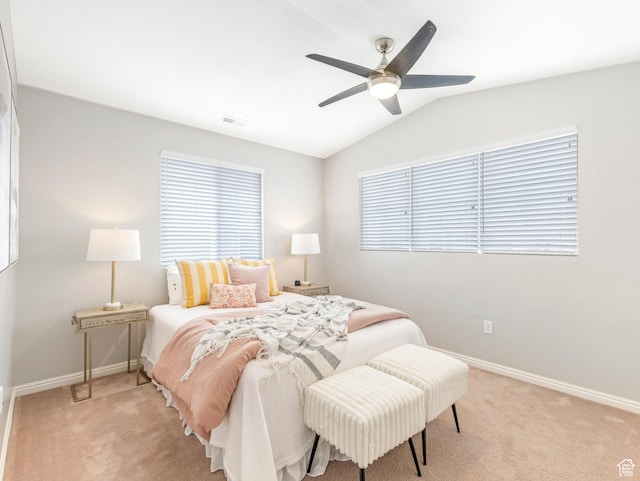 bedroom with light colored carpet, baseboards, vaulted ceiling, and a ceiling fan