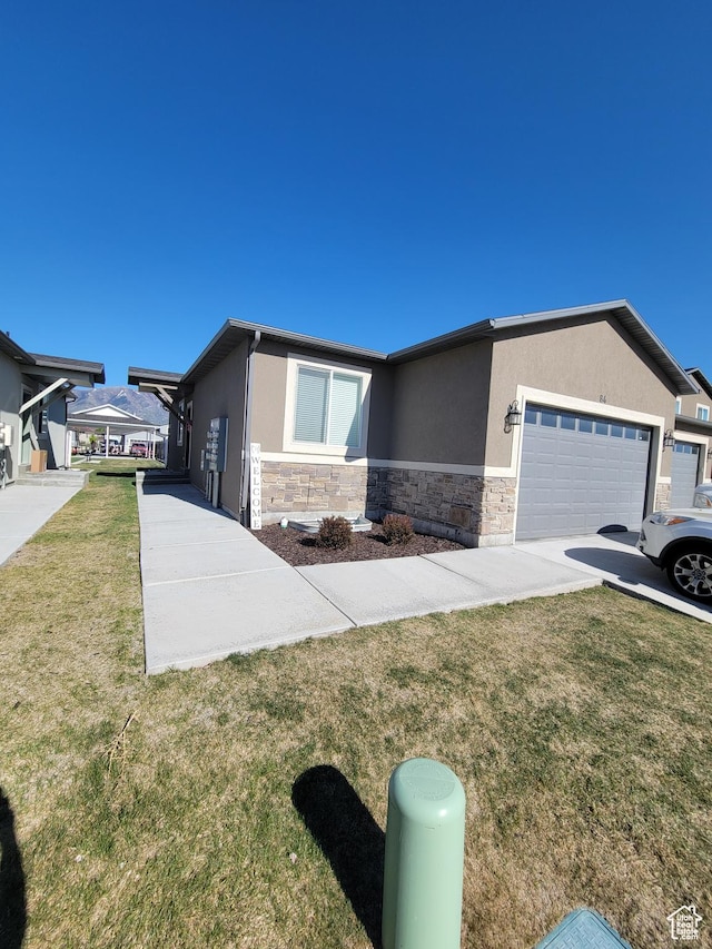 250 W 1200 S Unit 84, Tremonton, UT 84337 - ranch-style house featuring stucco siding, stone siding, an attached garage, and a front lawn
