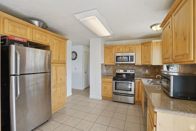 4372 S Wildrose Dr W, West Valley City, UT 84120 - kitchen with stainless steel appliances, a sink, light tile patterned floors, tasteful backsplash, and light stone countertops
