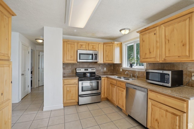4372 S Wildrose Dr W, West Valley City, UT 84120 - kitchen with appliances with stainless steel finishes, a sink, light tile patterned flooring, light brown cabinets, and a textured ceiling