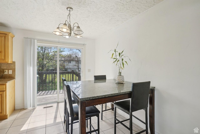 4372 S Wildrose Dr W, West Valley City, UT 84120 - dining room with a chandelier, light tile patterned floors, baseboards, and a textured ceiling