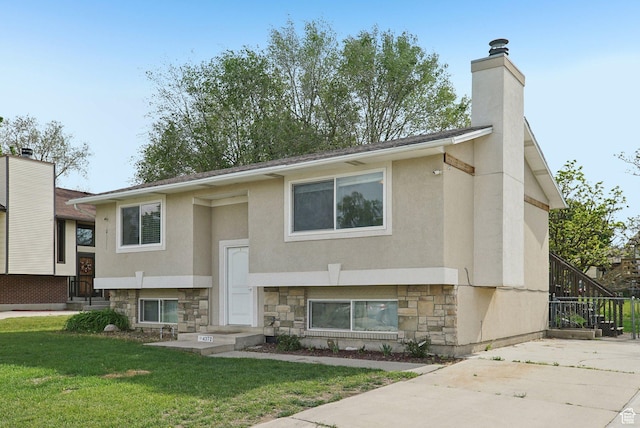 4372 S Wildrose Dr W, West Valley City, UT 84120 - raised ranch featuring stone siding, a front yard, a chimney, and stucco siding