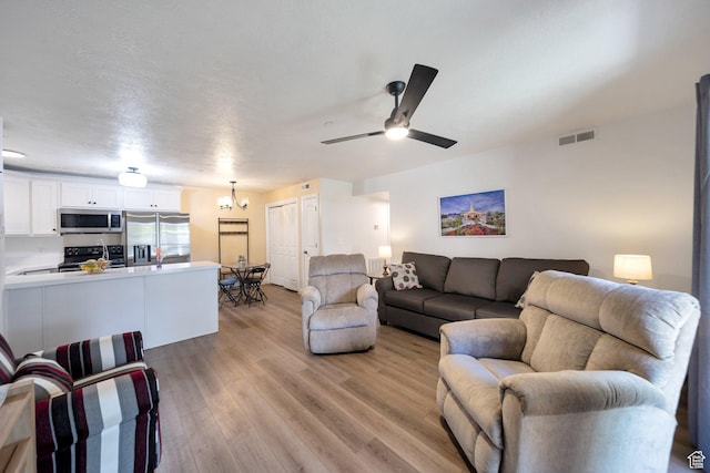 317 S 1000 W Unit 104, Pleasant Grove, UT 84062 - living area featuring light wood-style floors, a ceiling fan, and a chandelier