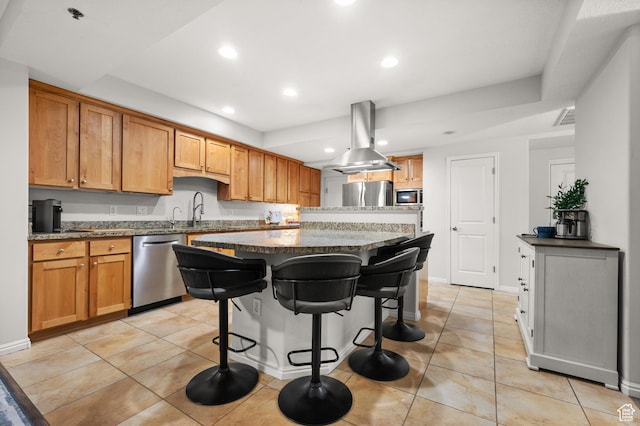 kitchen with appliances with stainless steel finishes, island range hood, a kitchen island, recessed lighting, and a kitchen breakfast bar