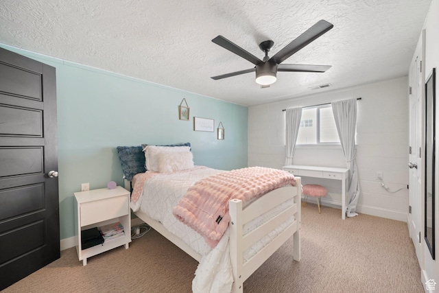 bedroom featuring light carpet, a textured ceiling, ceiling fan, and baseboards