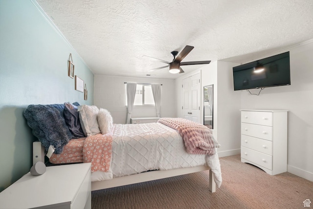 bedroom with light colored carpet, a textured ceiling, a ceiling fan, a closet, and baseboards