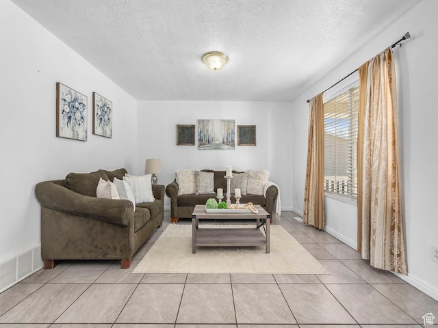 living room with a textured ceiling and light tile patterned floors