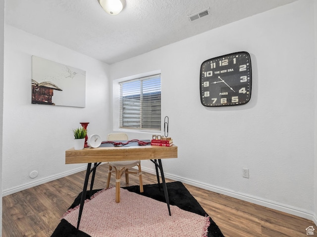 home office with baseboards, wood finished floors, and a textured ceiling
