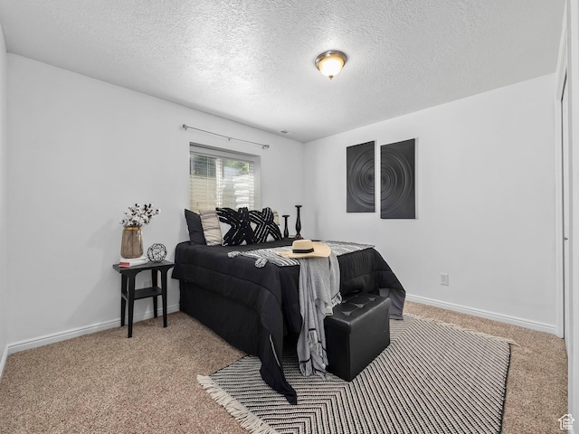 carpeted bedroom featuring a textured ceiling and baseboards
