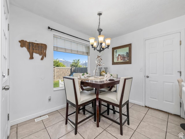 dining space featuring a chandelier, light tile patterned flooring, and baseboards