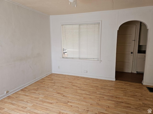 383 N 100 E, Price, UT 84501 - empty room featuring arched walkways, light wood finished floors, baseboards, and ornamental molding