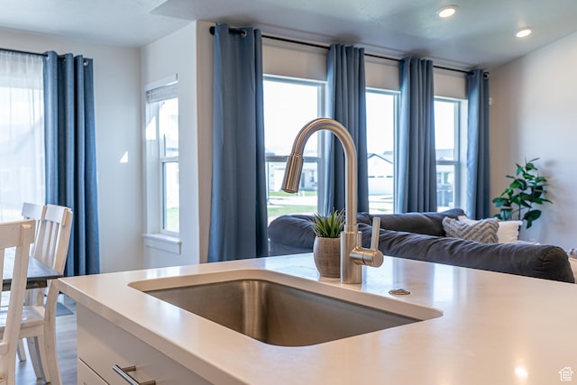 kitchen with light countertops, a sink, healthy amount of natural light, recessed lighting, and open floor plan