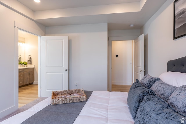 bedroom featuring light wood finished floors, recessed lighting, baseboards, and ensuite bathroom