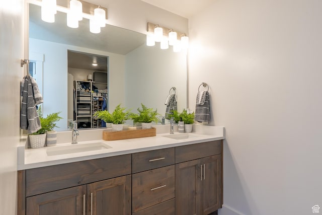 bathroom featuring double vanity and a walk in closet