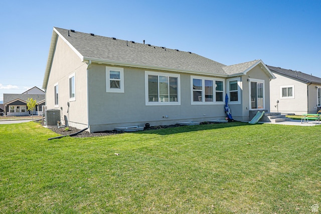 back of property with central AC, a lawn, stucco siding, and roof with shingles