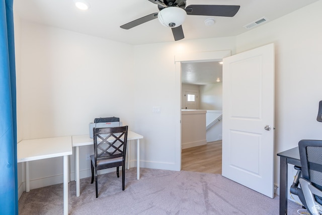 carpeted office space featuring ceiling fan