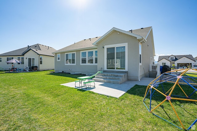back of property with a patio area, a lawn, stucco siding, and roof with shingles