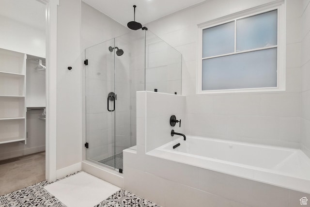 full bath featuring a shower stall, a spacious closet, and a bath