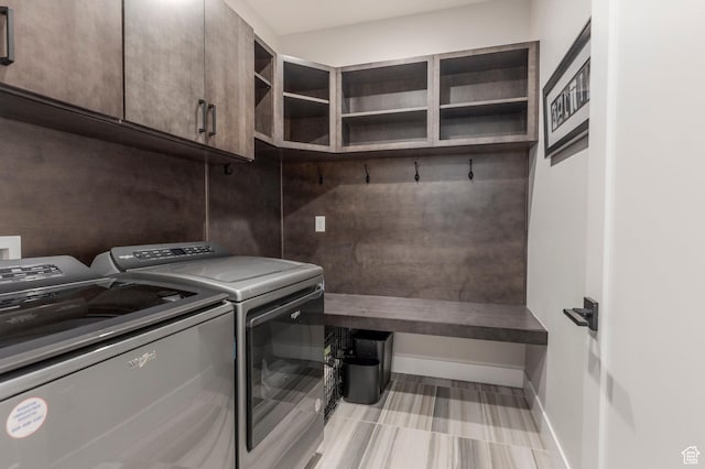 laundry area with washer and dryer, baseboards, and cabinet space