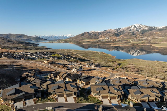 view of mountain backdrop featuring a large body of water and nearby suburban area