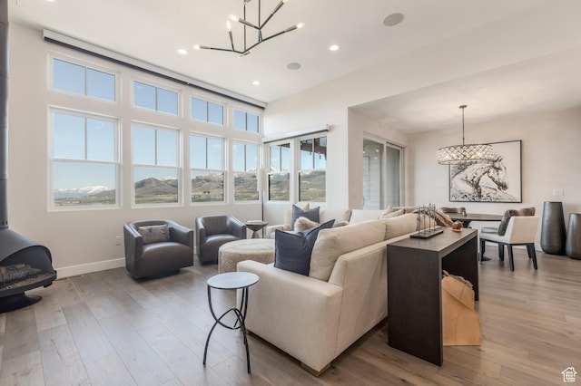 living area with a chandelier, hardwood / wood-style flooring, baseboards, and recessed lighting