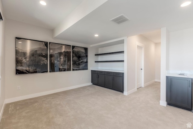 empty room featuring light colored carpet, recessed lighting, and baseboards