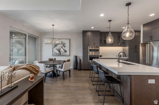 kitchen with a sink, stainless steel appliances, gray cabinetry, modern cabinets, and recessed lighting