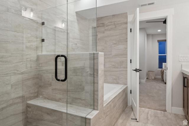 full bath with a stall shower, vanity, a bath, and baseboards