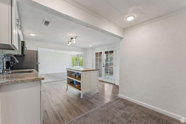1388 S 1300 E, Salt Lake City, UT 84105 - kitchen featuring a sink, a textured wall, white cabinets, crown molding, and baseboards