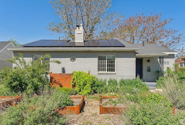 1388 S 1300 E, Salt Lake City, UT 84105 - rear view of house featuring a garden, solar panels, a chimney, and brick siding
