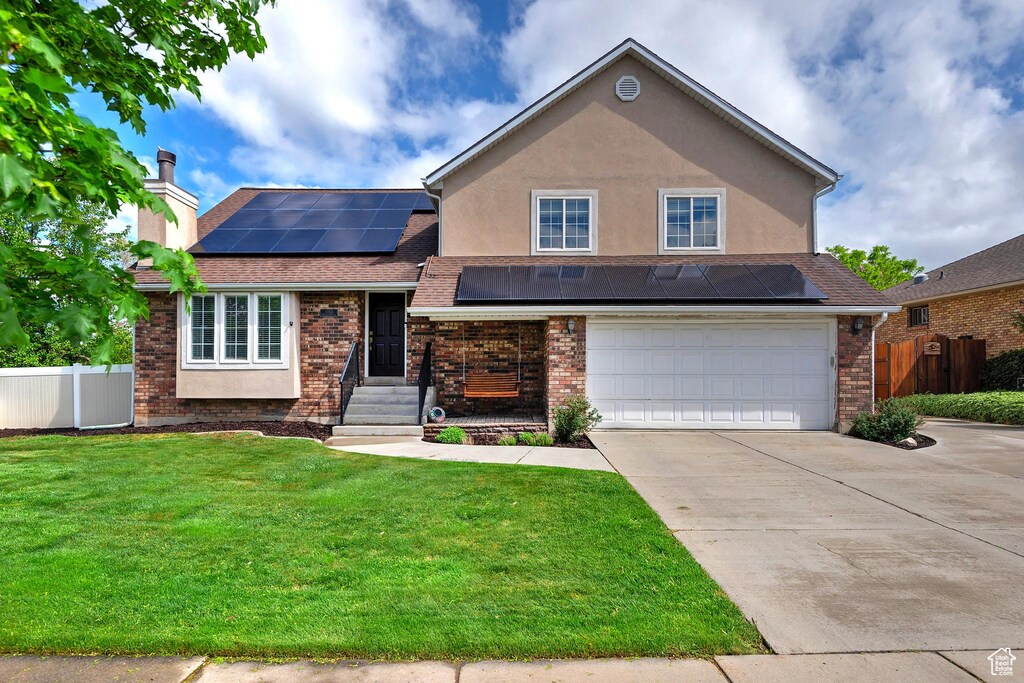 1088 W Walden Park Dr, Murray, UT 84123 - traditional home with roof mounted solar panels, concrete driveway, a garage, a chimney, and brick siding
